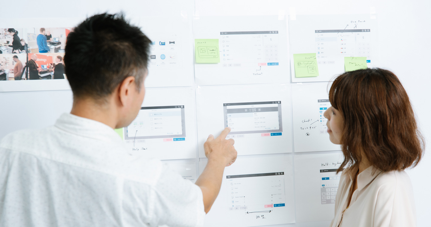 Photograph: Team members reviewing screen layouts at a meeting