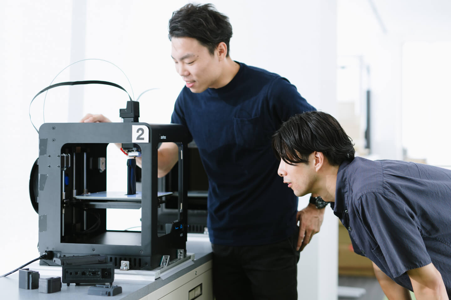 Photograph: Jun Shibayama and Naoaki Iwamatsu considering designs from a 3D printer