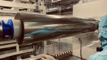 A worker inspecting a roll of transparent, highly water-resistant barrier film
