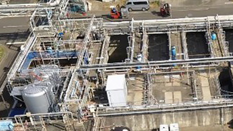 Aerial photograph of a wastewater treatment plant with rows of treatment tanks and piping
