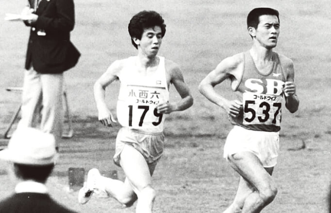 1984年東日本実業団陸上20000mにてエスビー食品陸上部の瀬古利彦と競り合う佐藤敏信。