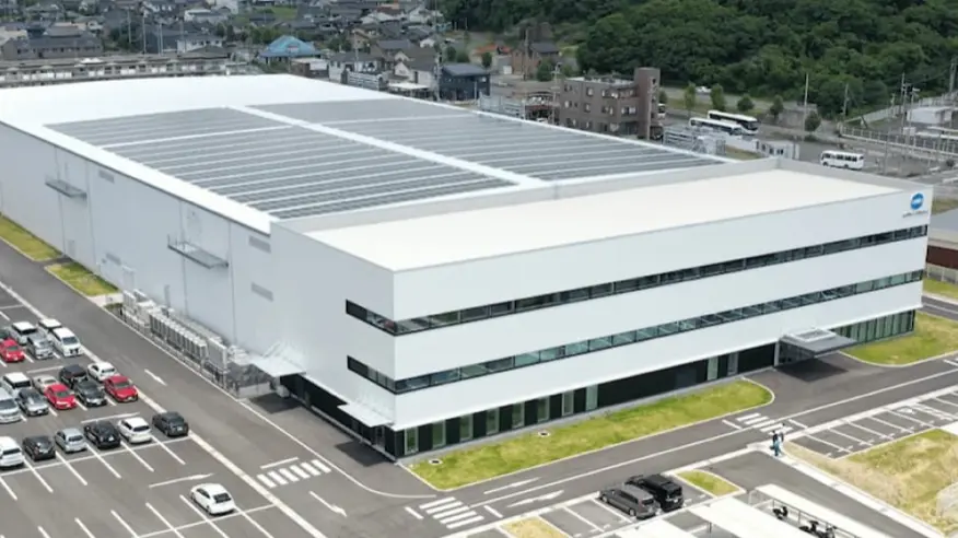 屋根に太陽光発電パネルを設置したコニカミノルタメカトロニクス社 豊川市本社を上空から見た写真