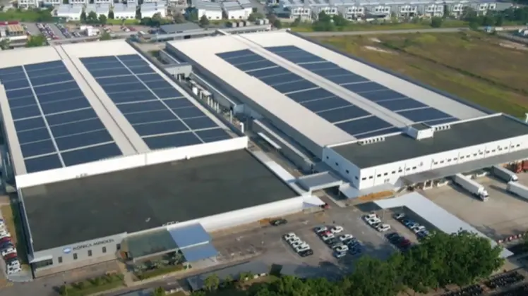 屋根一面に太陽光発電パネルを敷き詰めたコニカミノルタビジネステクノロジーズ（マレーシア）社の工場を上空から見た写真