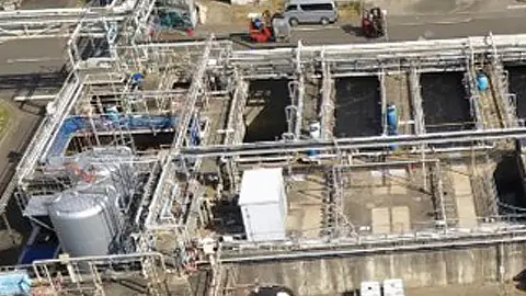 複数の処理槽と配管が並ぶ排水処理場を上空から見た写真