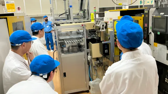 参加者が生産設備を見学する様子